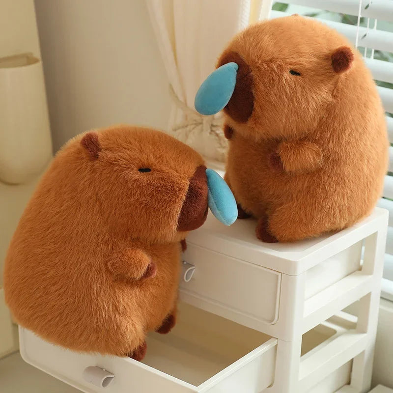 Two brown kawaii plush animals with blue accents on a white surface
