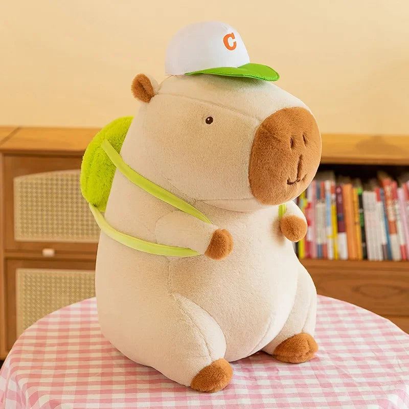 Kawaii plush toy hippo wearing a cap on a checkered surface with books in the background