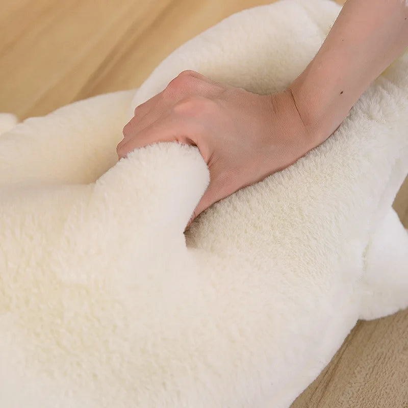 Close-up of a hand touching a soft, white kawaii-themed plush toy