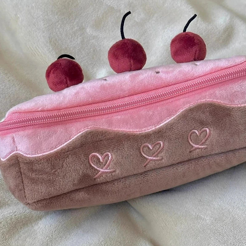 Pink plush pencil case with kawaii cherry decorations on a beige background