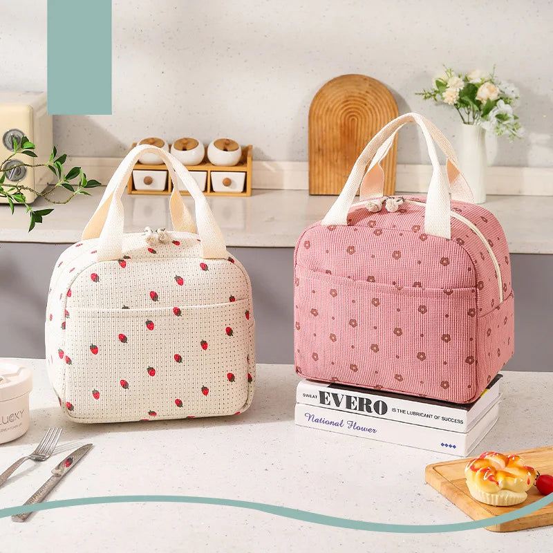 Two insulated kawaii lunch bags with floral patterns on a kitchen counter.