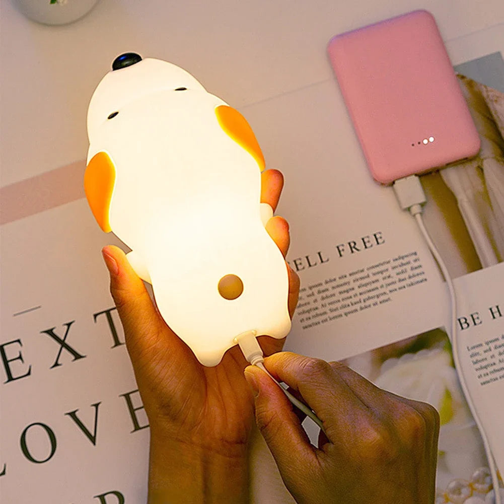 Hand holding a small, round, white kawaii lamp shaped like a dog