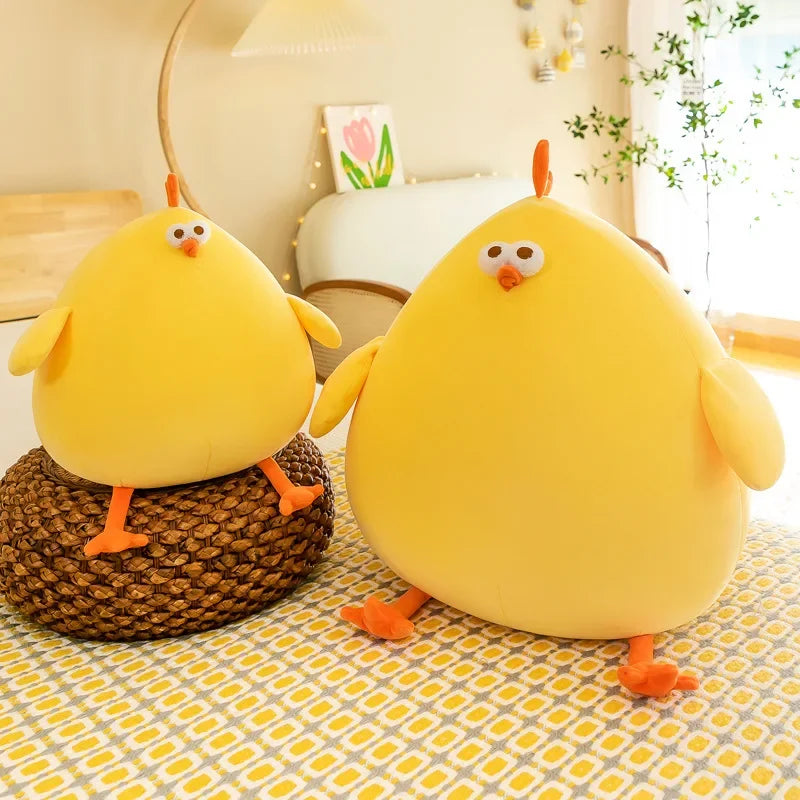 Two yellow kawaii plush toys resembling chickens on a patterned surface.