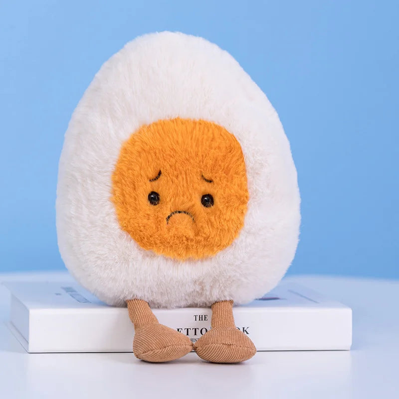 Plush kawaii toy resembling a boiled egg with a sad expression on a blue background