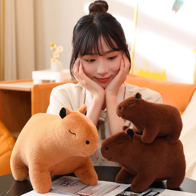 Woman sitting with two kawaii plush toys on a table in a cozy room.
