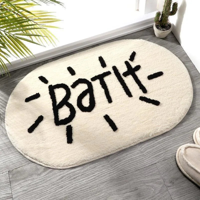 Kawaii Oval-shaped bath mat with 'Bath' text on a wooden floor.
