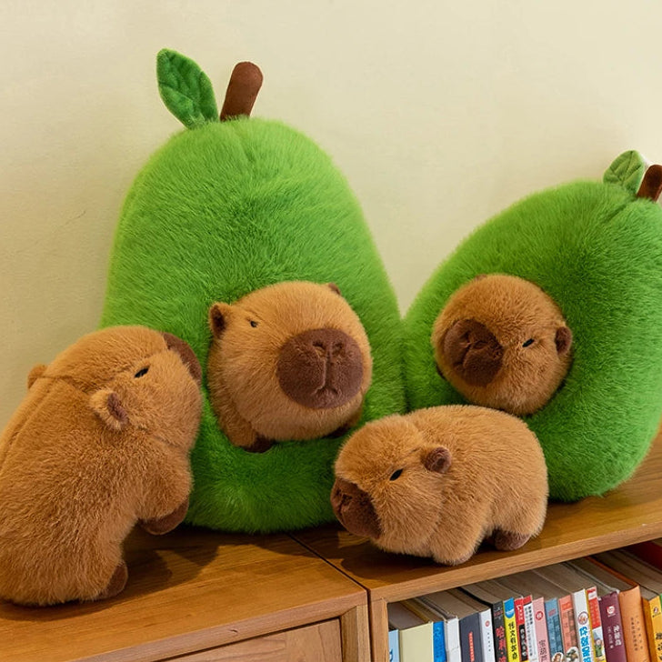 Kawaii plush toys shaped like guinea pigs and green avocados on a wooden surface with books in the background.