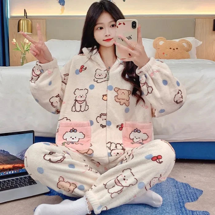 Person wearing a kawaii cartoon-themed pajama set sitting on a bed with a laptop.