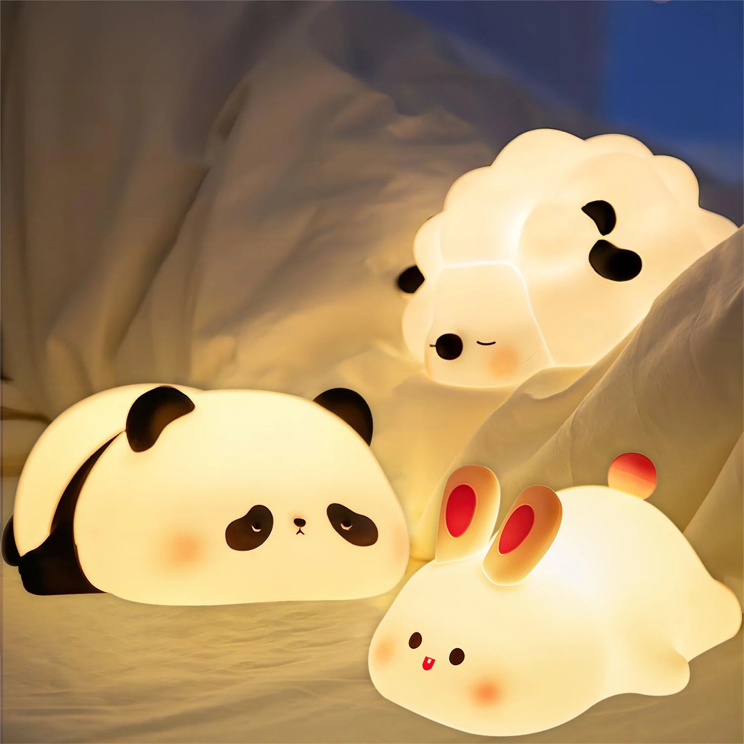 Three cute kawaii animal-shaped night lights on a soft surface.