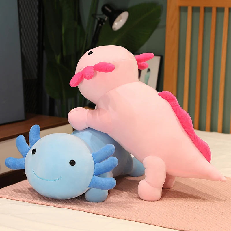 Two axolotl plush kawaii toys, one pink and one blue, on a table.