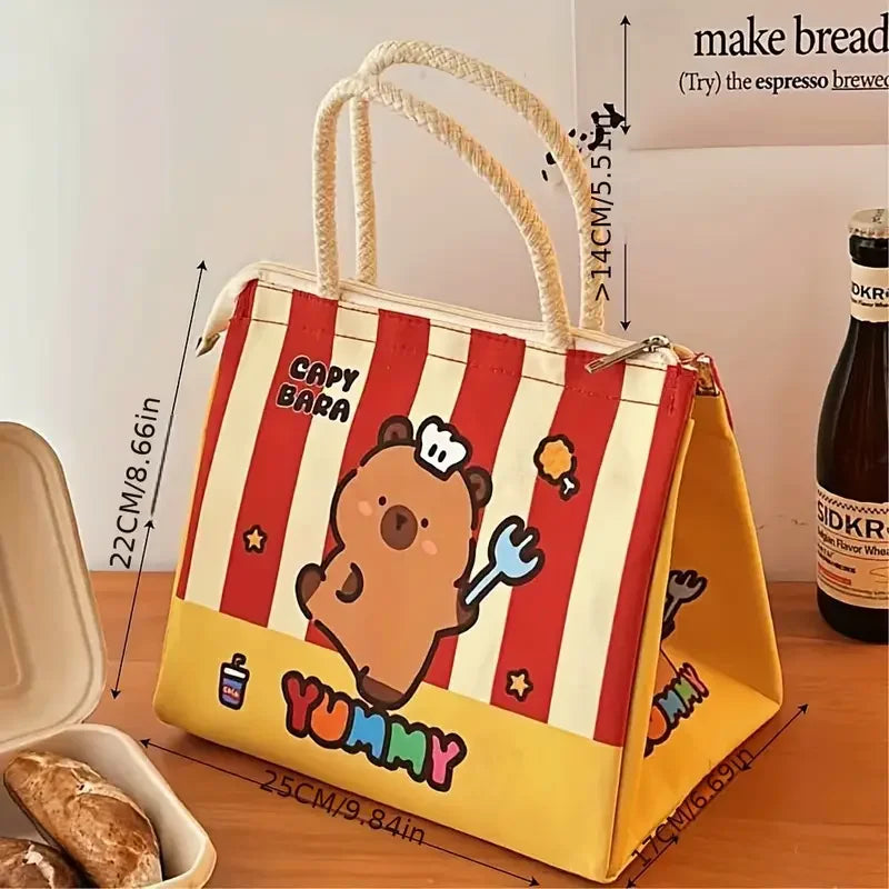 Cartoon kawaii bear-themed lunch bag with red and yellow stripes on a wooden surface.