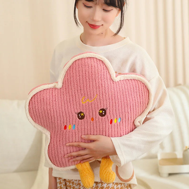 Person holding a pink cloud-shaped kawaii pillow with a smiling face design.