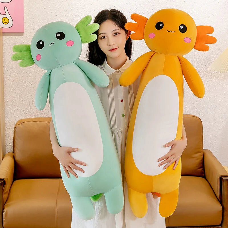 Woman holding two large kawaii plush toys, one green and one orange, against a neutral background.
