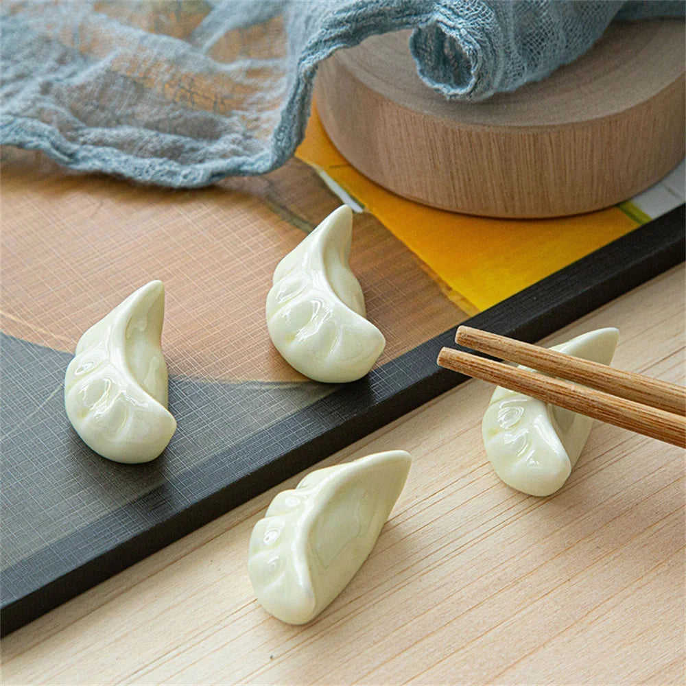 Three kawaii dumplings on a wooden surface with chopsticks and a blue cloth in the background.