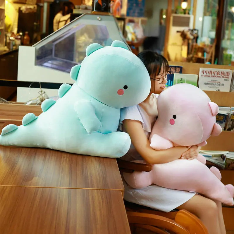 Child holding a green dinosaur kawaii plush toy and a pink sheep plush toy in a store setting.