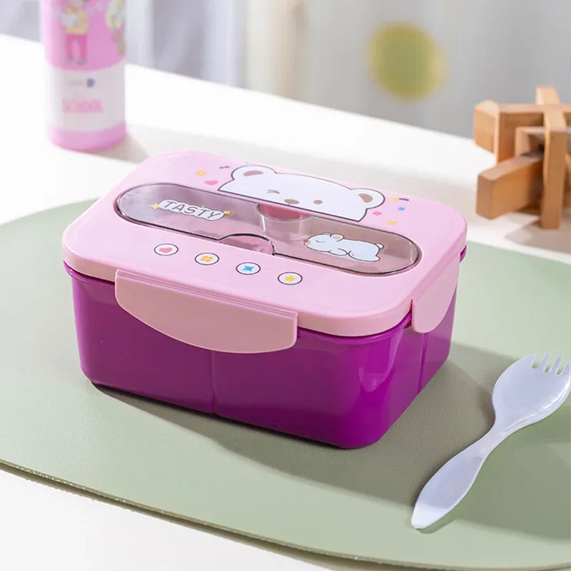 Pink and purple kawaii lunch box with cartoon design on a green surface