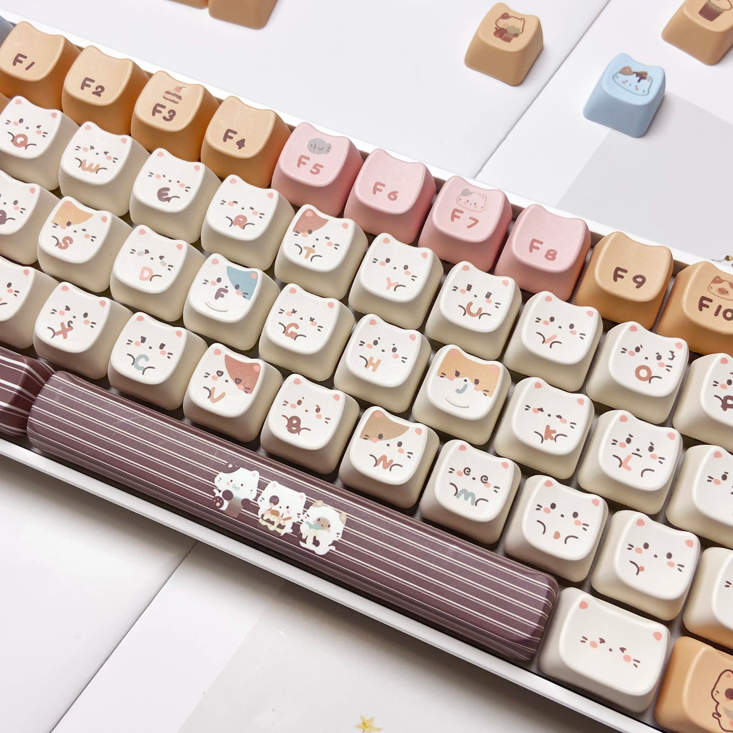 Keyboard with Kawaii cat-themed keys on a white surface