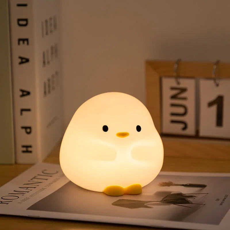 Cute chick-shaped kawaii night light on a magazine with a calendar in the background