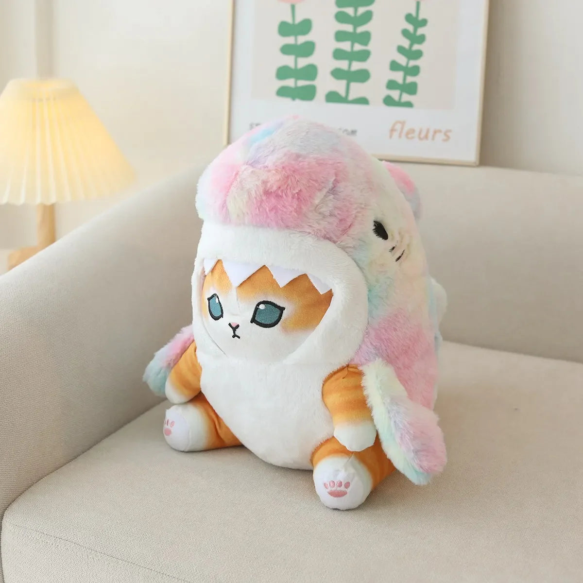 Kawaii plush toy resembling a cat with rainbow fur on a couch