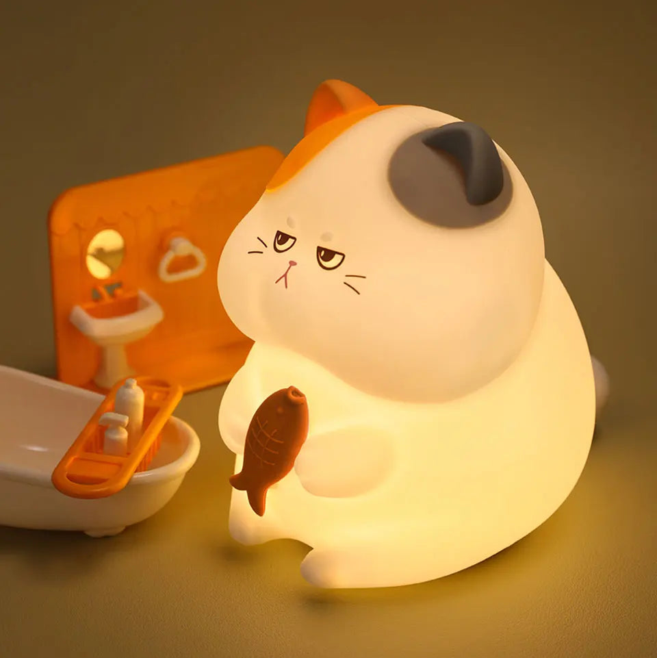Cat-shaped kawaii night light with fish design on a dark background