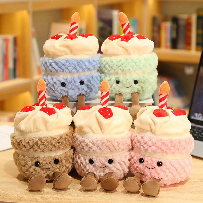 Set of plush cake kawaii toys with candles on a wooden surface.