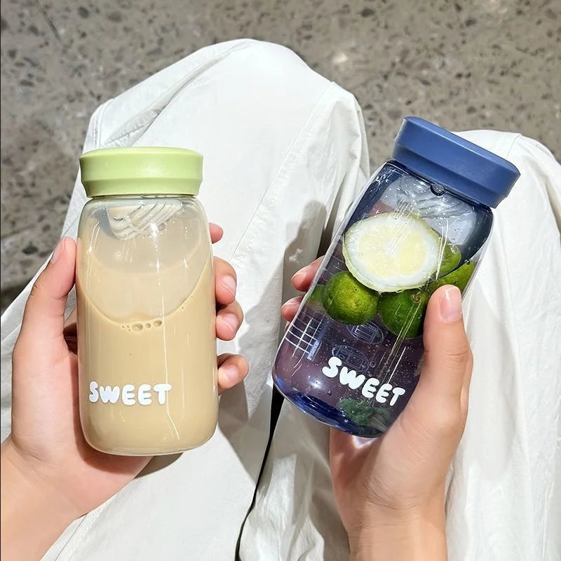 Two hands holding drinks in 'sweet' labeled Kawaii-inspired bottles with a neutral background