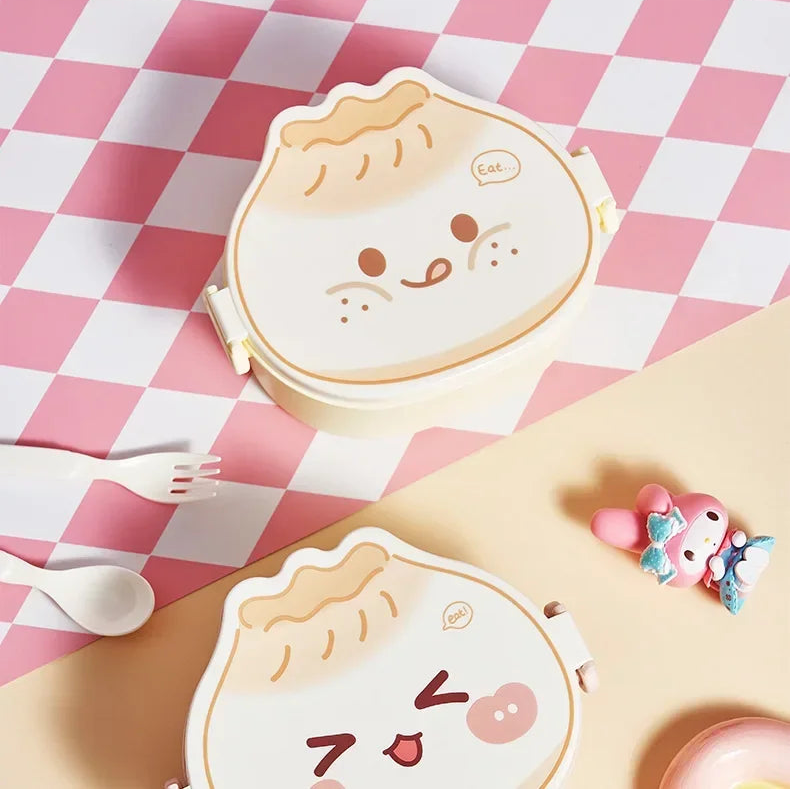 Two kawaii cartoon-style bento boxes on a pink and white checkered tablecloth.