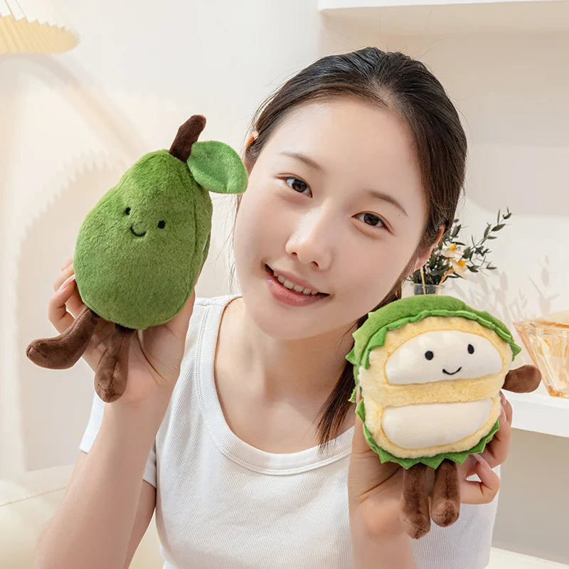 Person holding two plush avocado kawaii toys against a neutral background