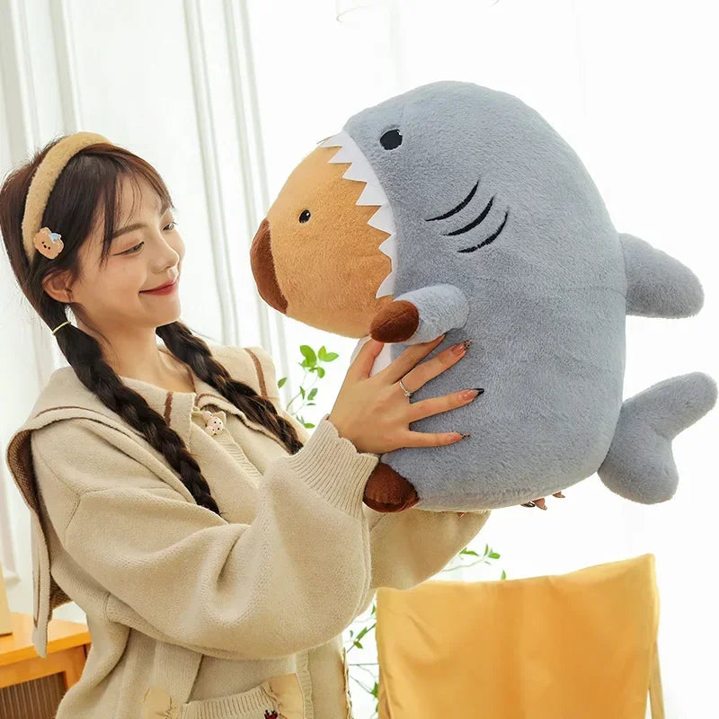 Person holding a large kawaii plush shark toy in a bright room