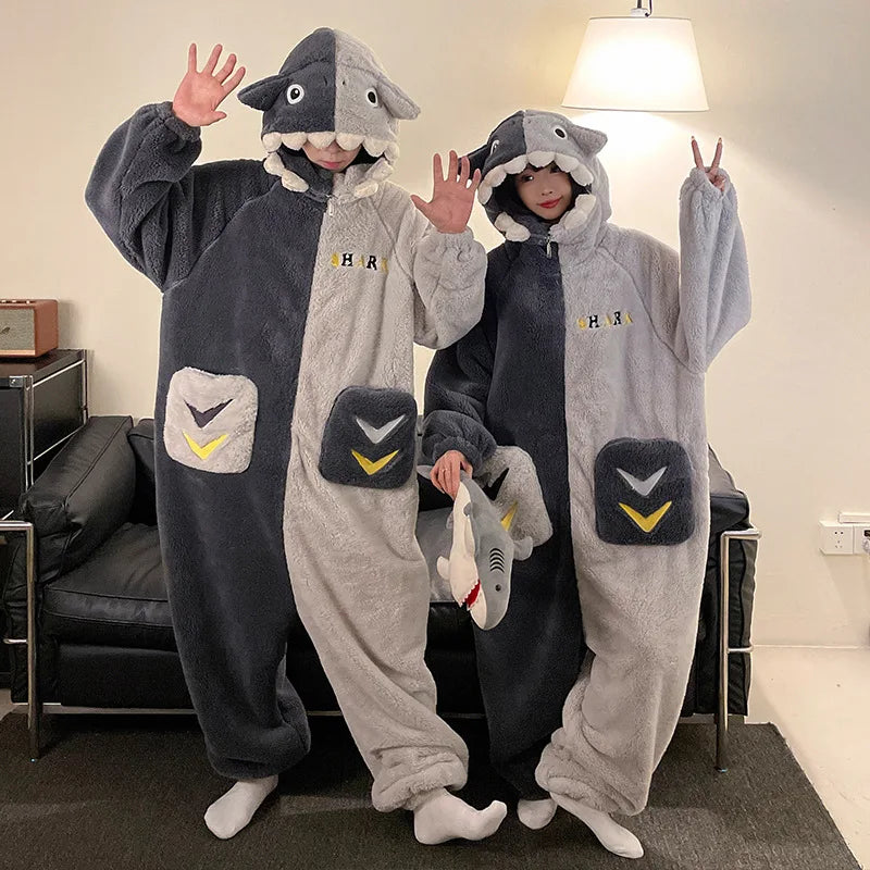 Two people wearing kawaii shark-themed onesies in a room.