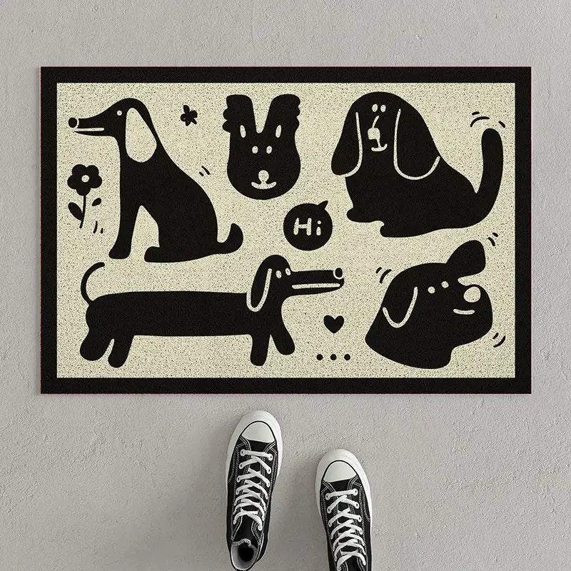 Doormat with Kawaii black dog illustrations on a beige background, placed on a gray floor with shoes in front.