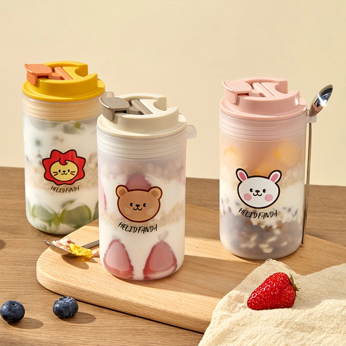 Three colorful tumblers with Kawaii animal-themed designs on a wooden surface.