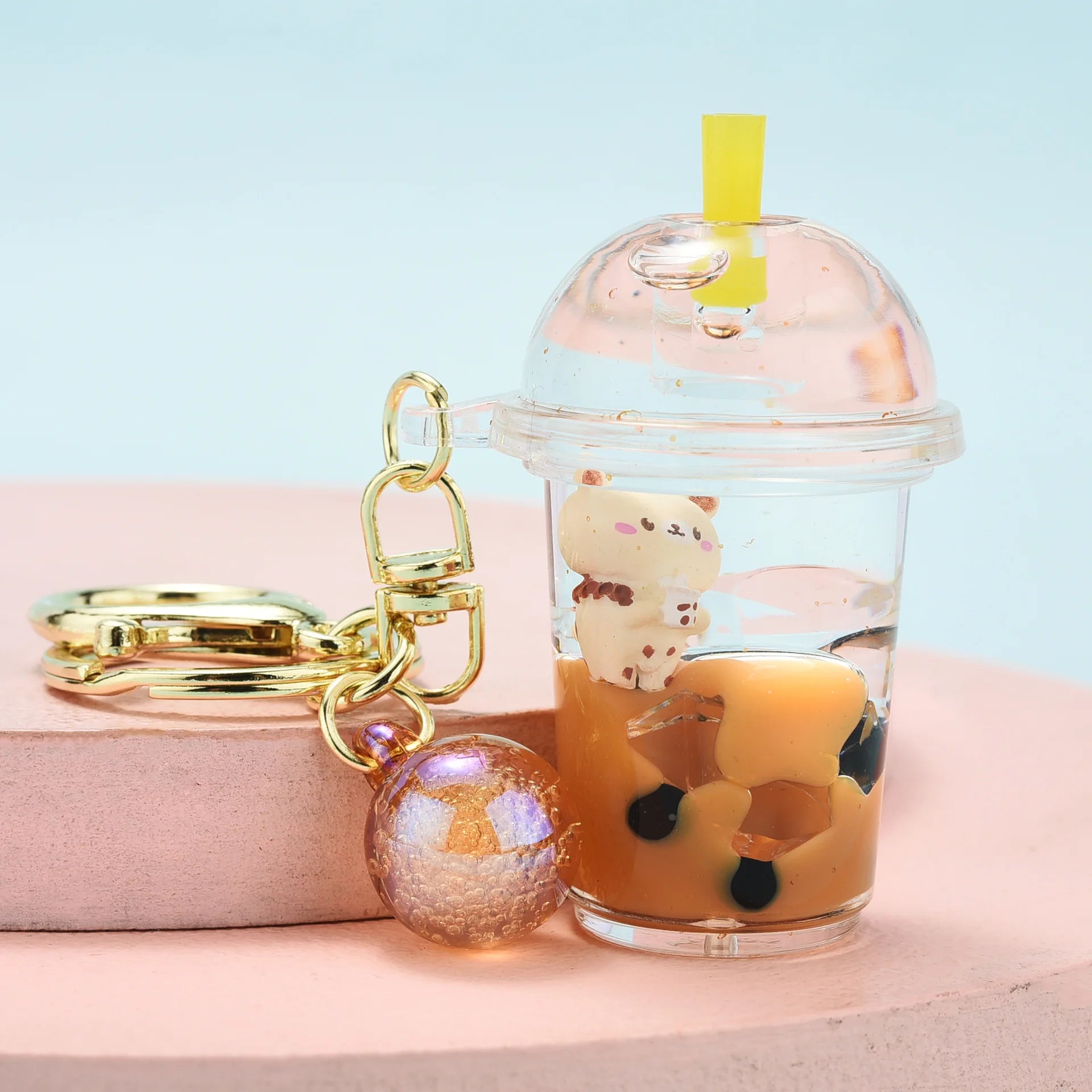Keychain shaped like a kawaii bubble tea with a cat design on a light blue background