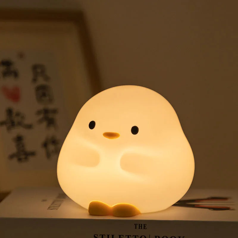 Cute chick-shaped kawaii night light on a surface with a blurred background