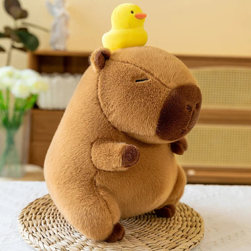 Kawaii plush toy beaver with a yellow rubber duck on its head, placed on a woven mat.