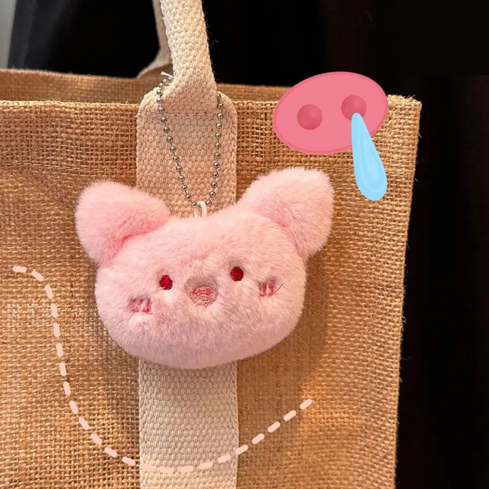 Pink plush kawaii keychain attached to a brown bag with a cartoon raindrop icon above it.