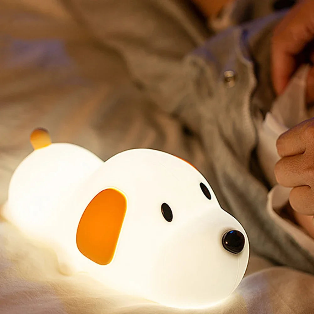 Cute dog-shaped kawaii night light on a soft surface with a blurred background
