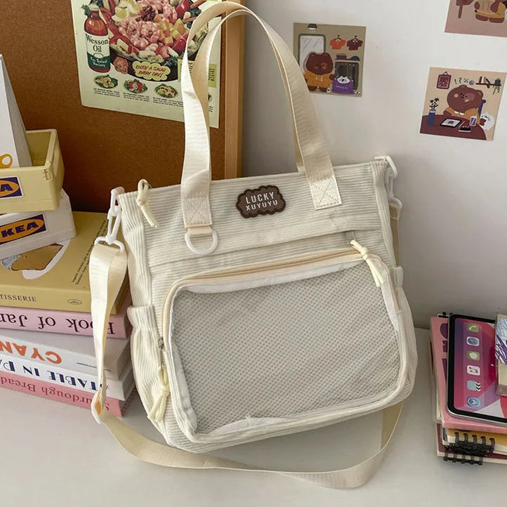 Beige Kawaii tote bag with mesh side pocket on a surface with books and a phone in the background