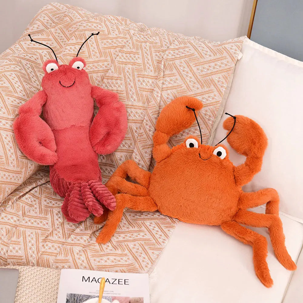 Kawaii plush toy lobster and crab on a patterned surface with a magazine underneath.