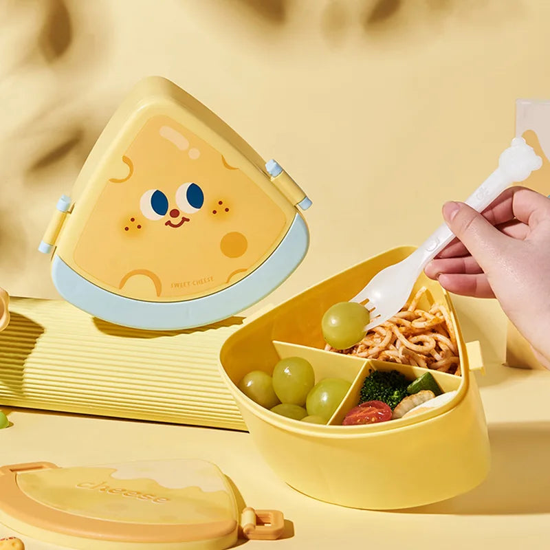 Yellow kawaii bento box with cartoon face design, filled with food, on a matching yellow background.