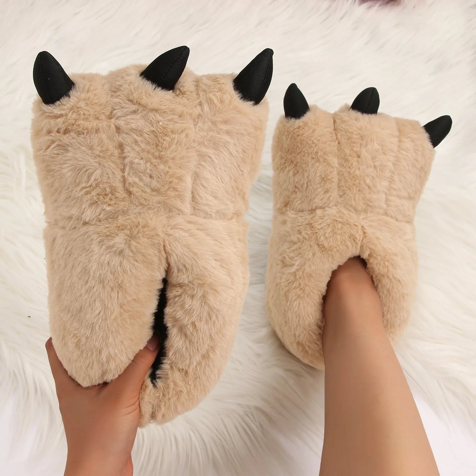 Beige fluffy kawaii slippers with black accents worn by a person on a soft white background
