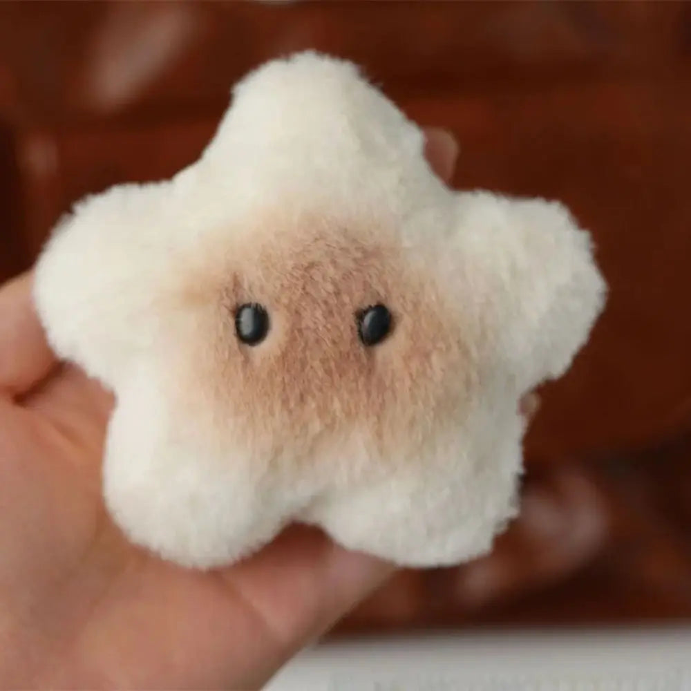 Small kawaii plush toy resembling a cloud with a face on a blurred background