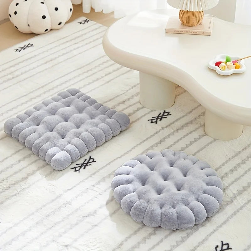 Two gray kawaii cushion pads on a textured white floor with a blurred background.