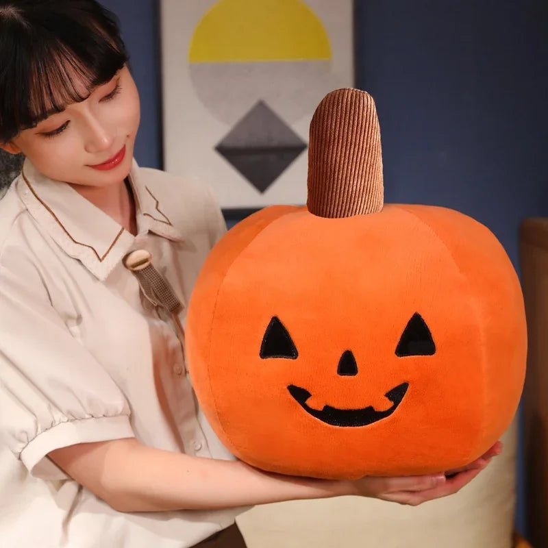 Person holding a kawaii plush pumpkin with a smiling face design.