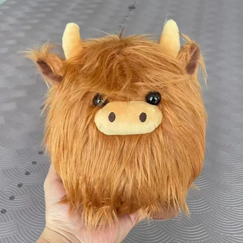Kawaii plush toy resembling a brown cow held in a hand against a gray background