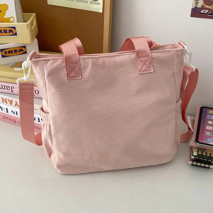 Pink Kawaii tote bag on a desk with books and a phone in the background