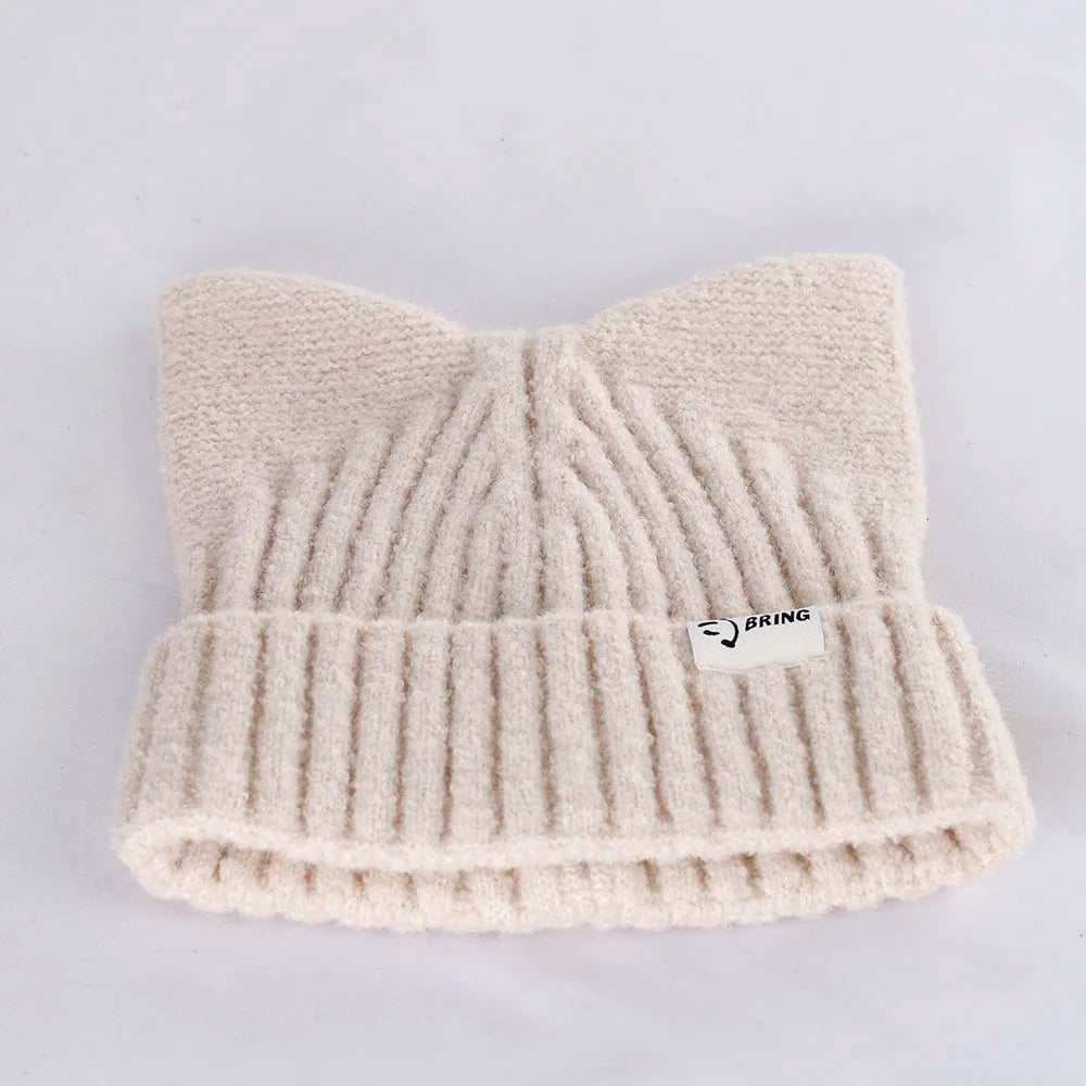 Beige knit Kawaii beanie with a brand logo on a light gray background