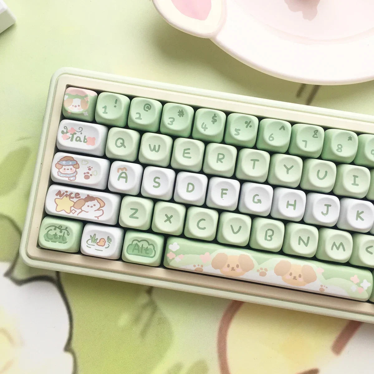 Small Kawaii keyboard with cute keycaps on a light green surface