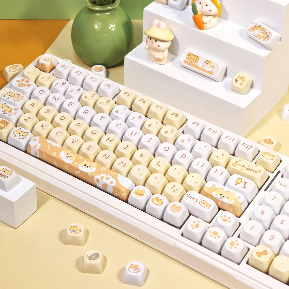 Keyboard with Kawaii cartoon keycaps on a desk with small decorative items