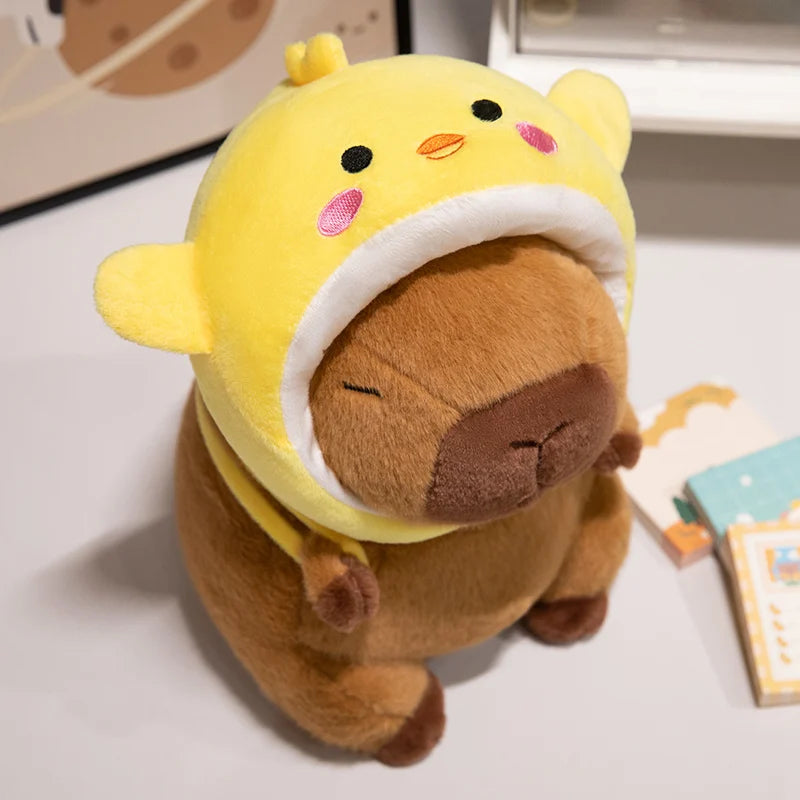 Kawaii plush toy with a yellow hood and brown body on a light surface